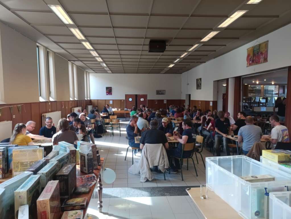 Volle zaal met spelers aan tafel tijdens het DoKaPi-toernooi